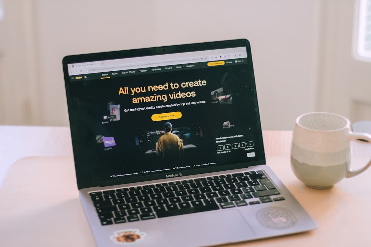 A laptop computer sitting on top of a white table next to a mug